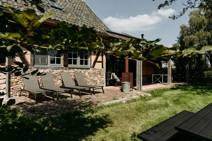 Ferienhäuschen 't Bakhuisje van vrouw Holle mit Liegestühlen im Garten